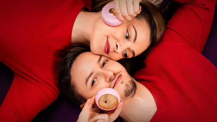 A man and woman enjoying Valentine's Day sales gifts, lovingly laying head to head, and treating each other to a UFO facial spa
